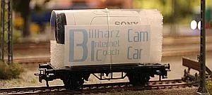 Minikamera motiert auf einem Modellbahnwagen steht auf einem Gleis
