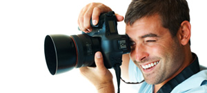Fotograf mit Spiegelreflexkamera fotografiert nach links
